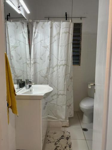 a bathroom with a sink and a shower curtain at Sunny Beachfront Apartment in Nerántza