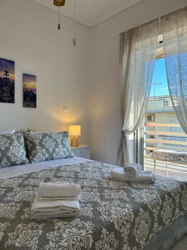 a bedroom with a bed with towels on it at Sunny Beachfront Apartment in Nerántza