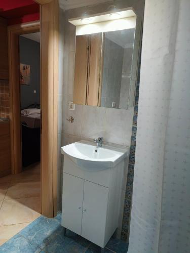 a bathroom with a white sink and a mirror at Magda's apartments in Perea