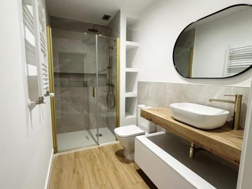 a bathroom with a sink and a toilet and a mirror at MUNDAKA Centre 2 in Mundaka