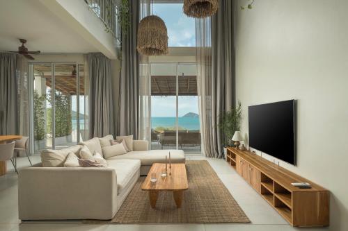 a living room with a white couch and a flat screen tv at Villa Vista, 5BR Beach Front SeaView Haven, Steps to Sand in Haad Pleayleam