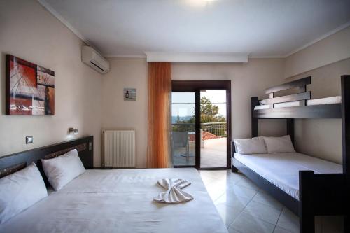 a bedroom with two beds and a balcony at Villa Amalia Sun Beach in Nea Vrasna