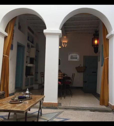 an archway in a house with a table and a dining room at RIAD Adam in Sidi Ifni