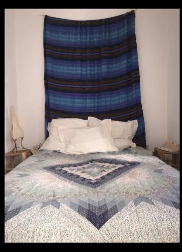 a bed with a blanket on top of it at RIAD Adam in Sidi Ifni