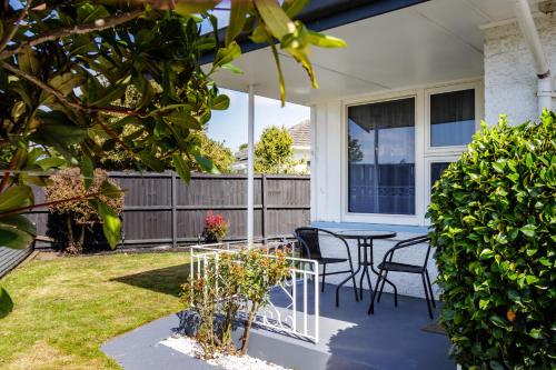 a patio with a table and chairs in a yard at Belle Bonne Motel in Christchurch