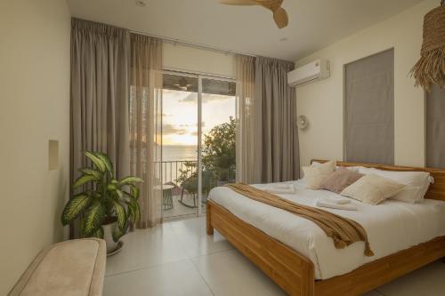 a bedroom with a bed with a view of the ocean at Villa Vista, 5BR Beach Front SeaView Haven, Steps to Sand in Haad Pleayleam