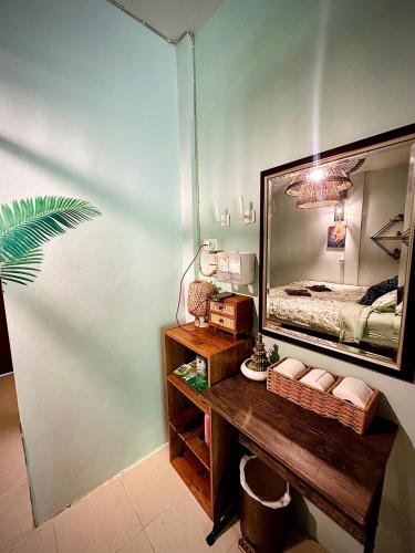 a bedroom with a large mirror and a wooden table at MILD ISLAND STAY ROOm in Phi Phi Islands