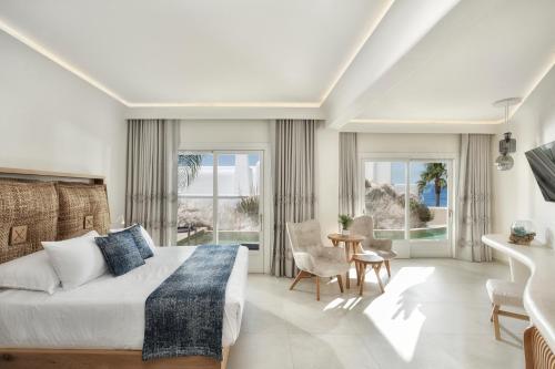 a bedroom with a bed and a table and chairs at Anax Resort and Spa in Agios Ioannis Mykonos