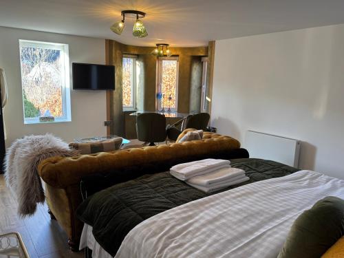 a bedroom with a bed and a desk and chairs at Gamelin in Llangollen
