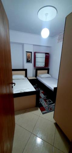 a small room with two beds and a door at Apartament martin 3 in Vlorë