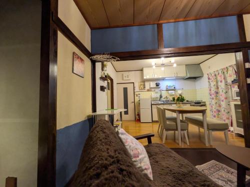 a living room with a couch and a kitchen at happy stay HANA in Sakaide
