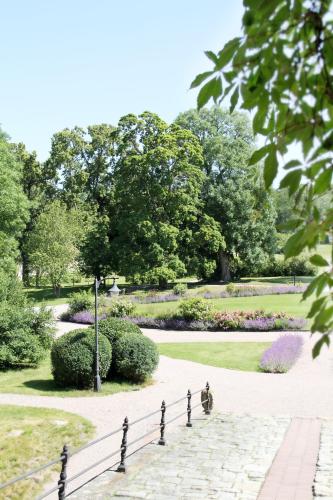 una persona sentada en un banco en un parque en Wiks Slott, en Vik