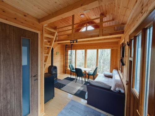 a room with a bed and a table with chairs at Bear Watching Tiny House in Lupeni