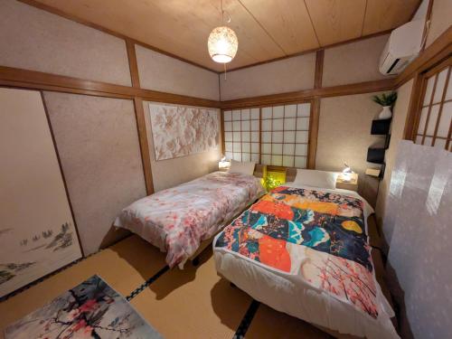 a bedroom with two beds in a room at happy stay HANA in Sakaide