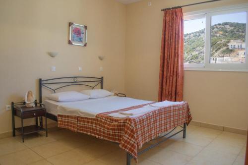 a bedroom with a bed and a large window at Dorana Apartments & Trekking Hotel in Diafani