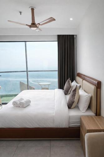 a bedroom with a large bed with a large window at Yamunaviewnest in Noida