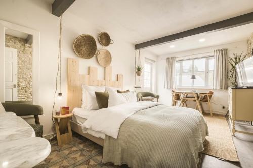 a bedroom with a large bed and a table at The Grain store in Cirencester