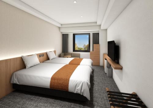 a hotel room with a large bed and a window at Daiwa Roynet Hotel Ginza PREMIER in Tokyo