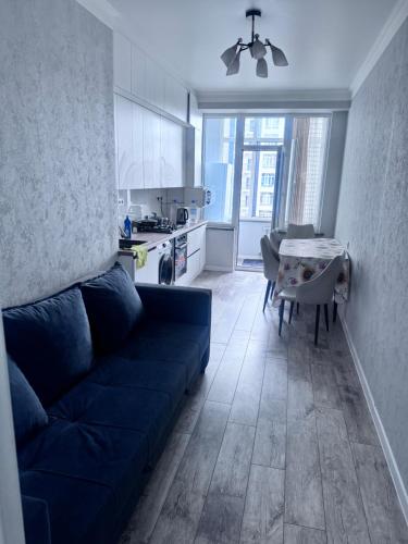 un soggiorno con un divano blu e una cucina di Elit house a Bishkek