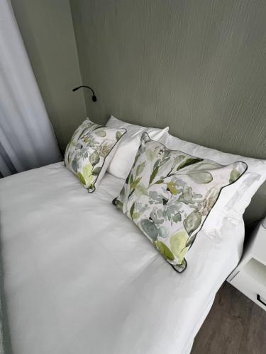 a white bed with a pillow and a lamp on it at Maple and Vine in Hilton