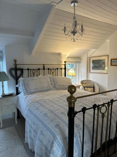a bedroom with a large bed and a chandelier at Trewetha Cottage Bed & Breakfast in Port Isaac