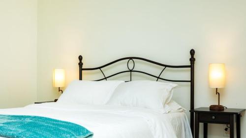 a bedroom with a white bed with two lamps at St Kitts Castle Suites in Basseterre