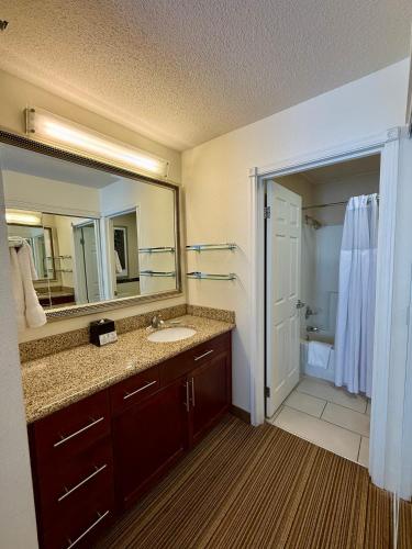 a bathroom with a sink and a large mirror at PrimeStay Extended Suites by IHG in Madison