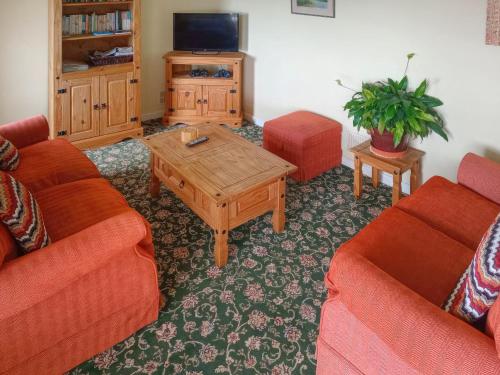 a living room with two couches and a coffee table at Vale View Cottage in Cinderford