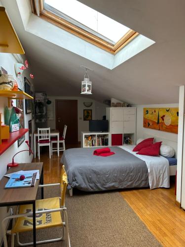 a bedroom with a bed with red pillows and a table at A Modo Mio - Monolocale - Zona Stadio Ospedale Maggiore in Bologna