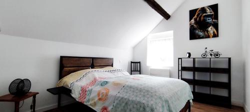 a bedroom with a bed with a comforter on it at Gîte Le Lyséas 6 personnes proche Forêt de Mormal & Animaux bienvenus in Bousies