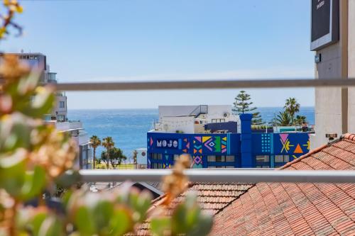 a woman sitting on a roof looking at the ocean at Atlantic Affair Boutique Hotel in Cape Town