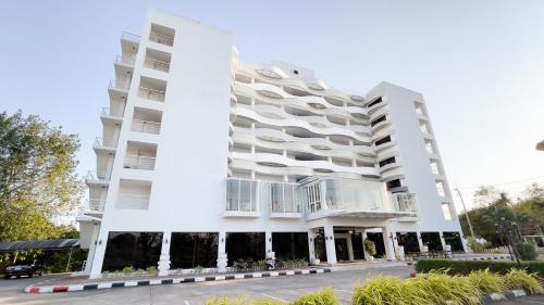 a large white building with balconies on it at Rua Rasada Express in Trang
