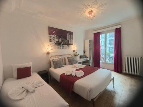 a bedroom with two beds and a window at Hotel Le Twelve in Paris