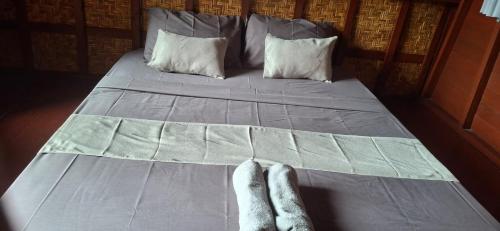 a bed with a pair of feet on it at Bungalow Bangket in Selaparang
