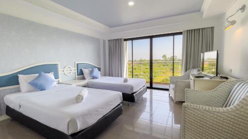 a hotel room with two beds and a couch at Rua Rasada Express in Trang
