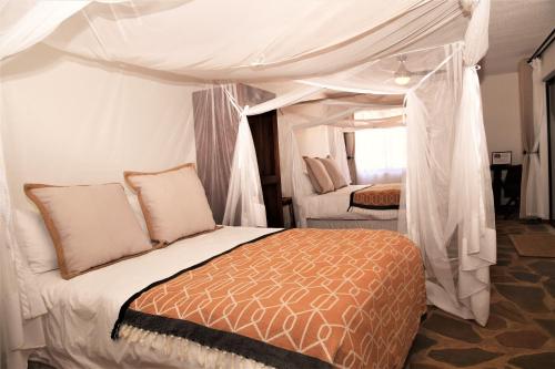 a bedroom with a bed with a canopy at Cheetah View Lodge at Cheetah Conservation Fund in Otjiwarongo