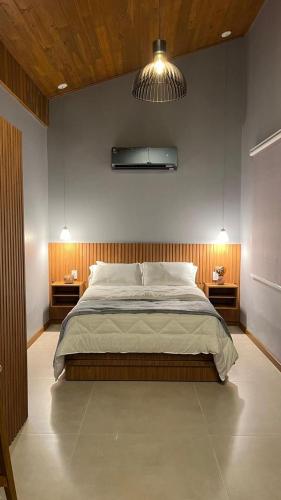 a bedroom with a large bed and two night stands at Vila Florença Chales in Santa Teresa