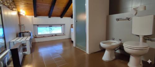 a bathroom with a toilet and a television in it at Il Nido Nel Bosco in Motta