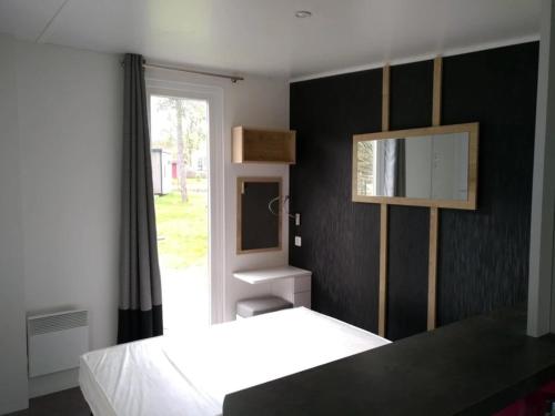 a bedroom with a white bed and a window at Camping 3 étoiles - Piscine - ccbfa0c in Saint-Mandé-sur-Brédoire