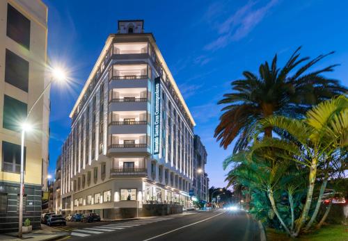 a tall white building on a city street at night at Barceló Santa Cruz Contemporáneo in Santa Cruz de Tenerife