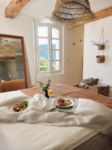 a table with two plates of food on a bed at Maison La Julianne in Callas