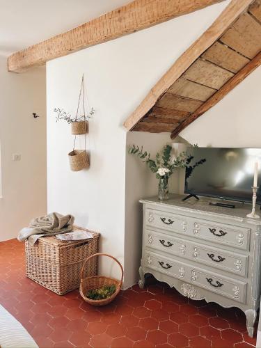 a room with a dresser with a television and a basket at Maison La Julianne in Callas