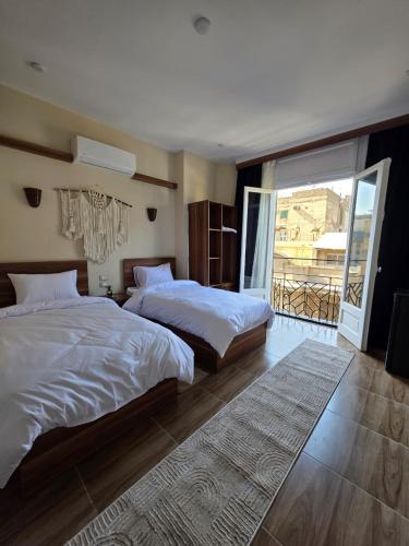 a bedroom with two beds and a balcony at Swisstay Downtown Cairo in Cairo