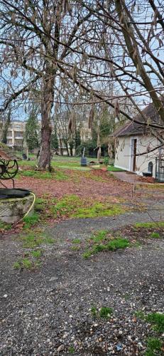 a park with a bench and a tree and a house at Studio plainpied in Saint-Doulchard