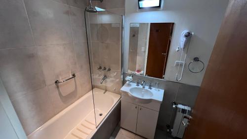 a bathroom with a tub and a sink and a shower at Hostería Huinganco in Huinganco