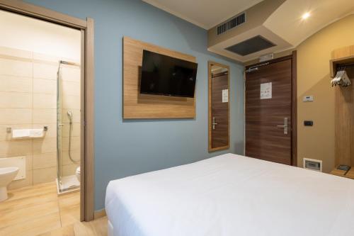 a bedroom with a bed and a shower and a television at Wyndham Garden Conegliano in Conegliano