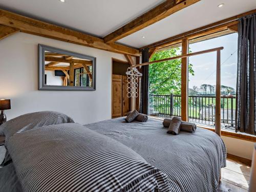 ein Schlafzimmer mit einem Bett und einem großen Fenster in der Unterkunft Bydown Lodge - Swimbridge Devon in Swimbridge