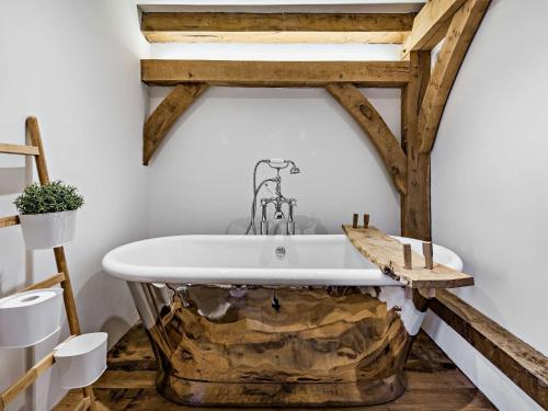 eine Badewanne in einem Badezimmer mit Holzbalken in der Unterkunft Bydown Lodge - Swimbridge Devon in Swimbridge