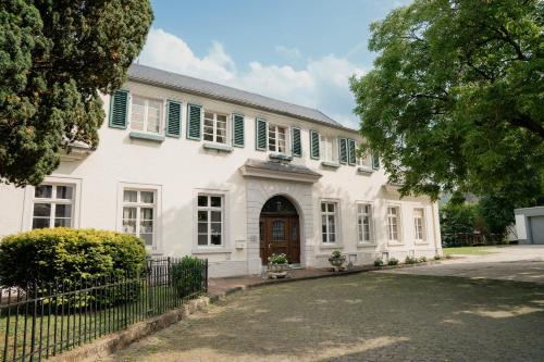 a white house with green shutters and a gate at KAROLINGERHOF - Mosel in Kröv