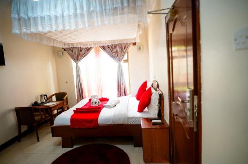 a bedroom with a bed with red pillows and a window at Explora Lodge in Arusha